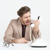 Hombre enfadado gritando al teléfono