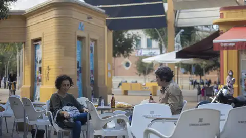 Dos personas consumen en la terraza de un bar antes de que se ordenase el uso obligatorio de las mascarillas en las mesas Dos personas consumen en la terraza de un bar antes de que se ordenase el uso obligatorio de las mascarillas en las mesas