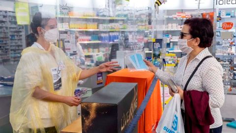 Una persona realiza la compra de varias mascarillas en una farmacia