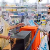 Una persona realiza la compra de varias mascarillas en una farmacia Una persona realiza la compra de varias mascarillas en una farmacia