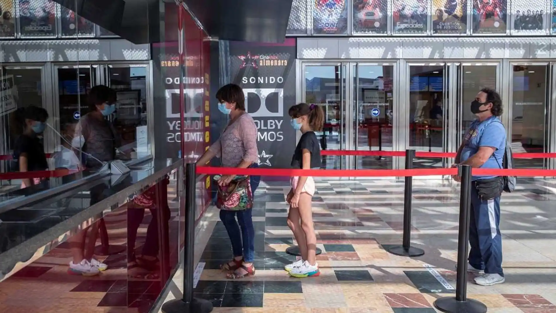 Varios espectadores hacen cola para comprar una entrada de cine