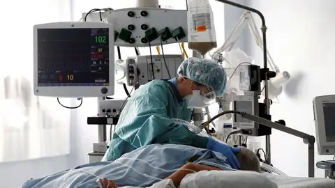 Una médico trata a un paciente de COVID-19 en una UCI.