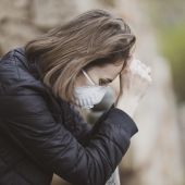 Una mujer con mascarilla sufre un ataque de ansiedad