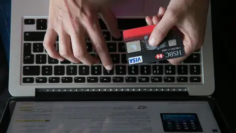 Una persona utiliza su tarjeta de crédito para pagar una compra online Una persona utiliza su tarjeta de crédito para pagar una compra online