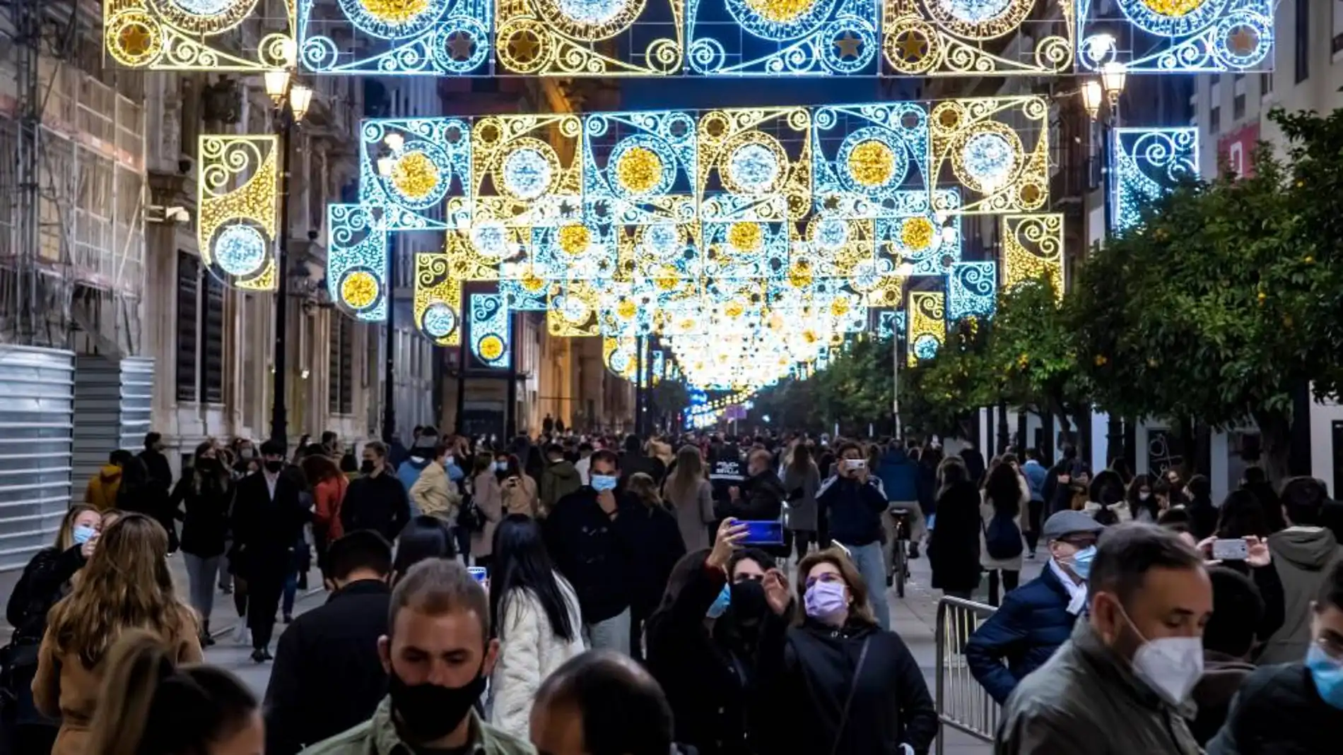 Varias personas disfrutan del encendido navideño en el centro de Sevilla. 