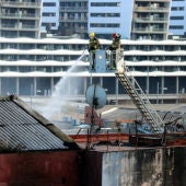 Bomberos en labores de extinción en la nave incendiada en Badalona.