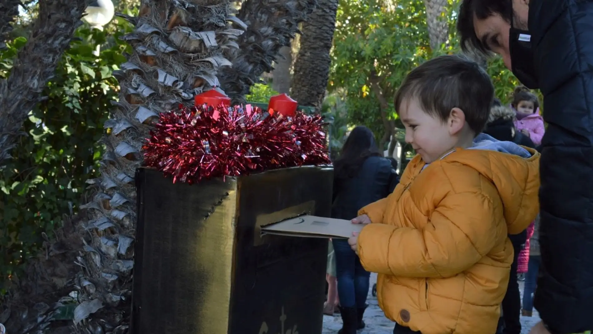 Un niño deposita su carta a los Reyes Magos en el buzón de La Rotonda del Parque Municipal de Elche.