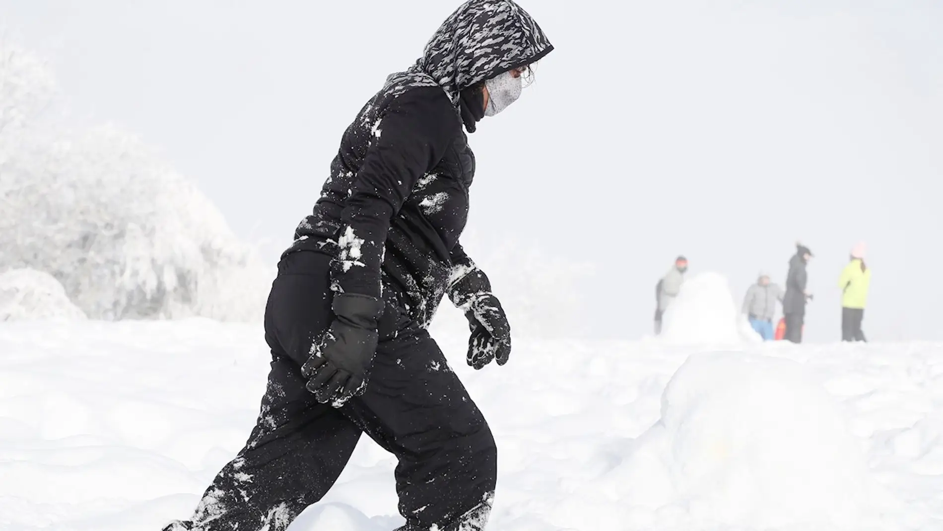 Una mujer camina entre la nieve de la localidad lucense de O Cebreiro.
