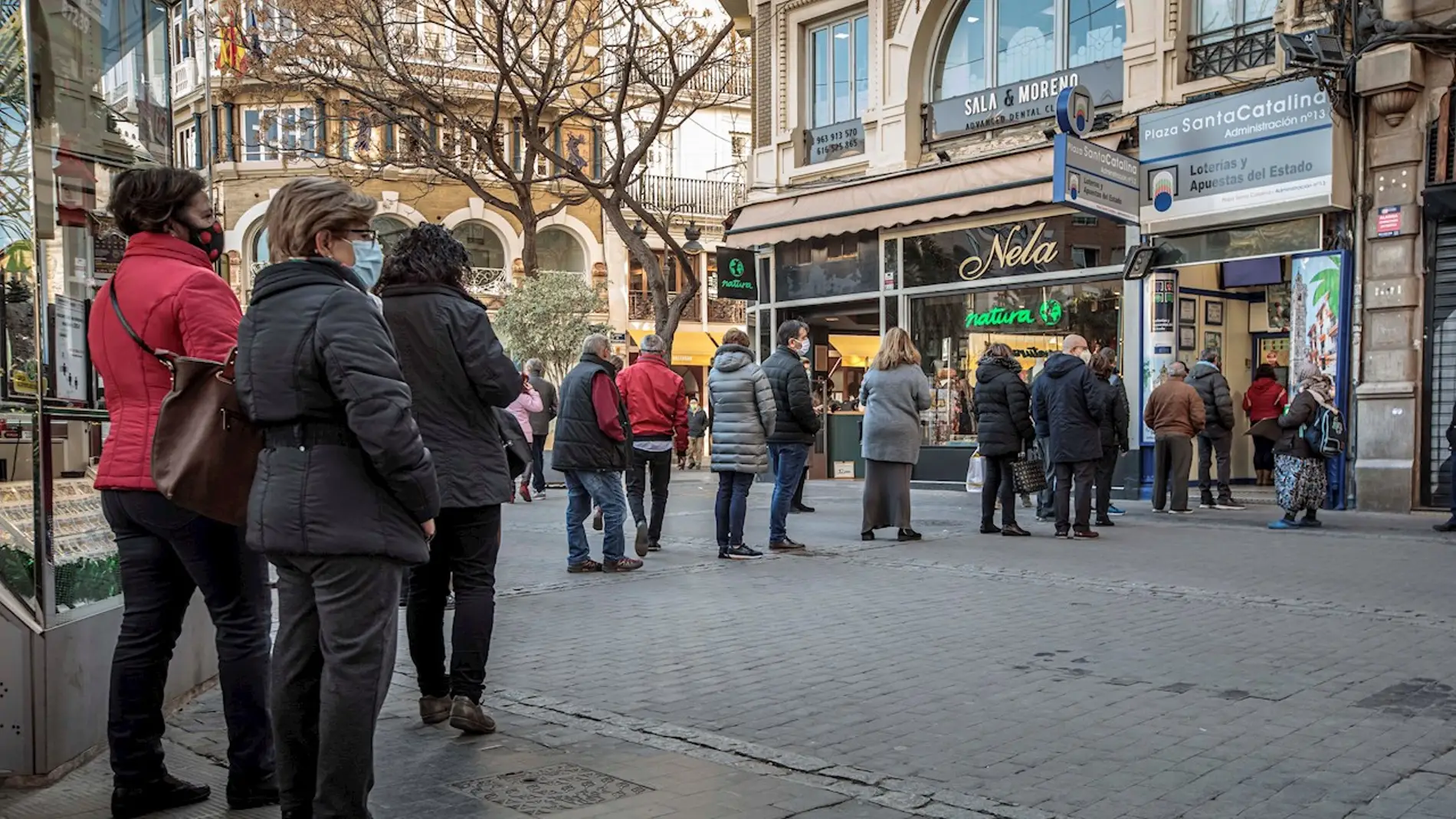 Varias personas hacen cola frente a una administración de lotería en Valencia