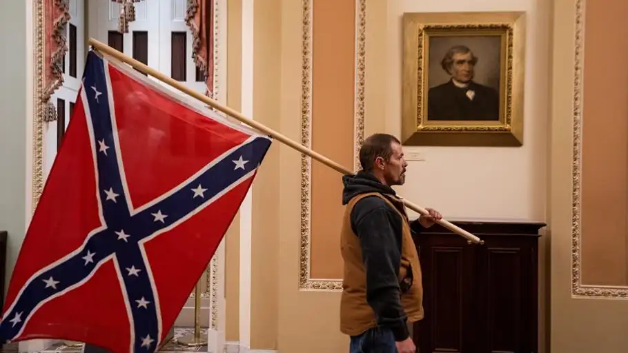 Un seguidor de Trump, con una bandera confederada en los pasillos del Capitolio Un seguidor de Trump, con una bandera confederada en los pasillos del Capitolio