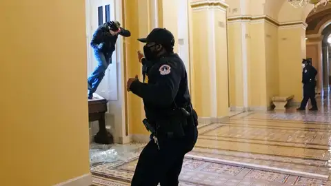 Un policía se defiende del asalto al Capitolio de Estados Unidos Un policía se defiende del asalto al Capitolio de Estados Unidos
