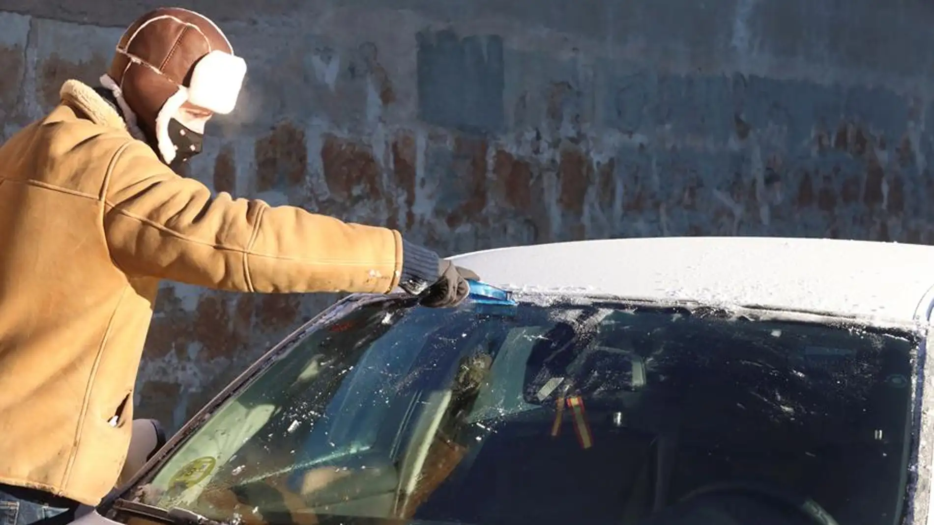 Un hombre quita la nieve de su coche 