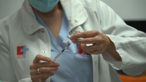 Profesional del SCS con una vacuna de Pfizer