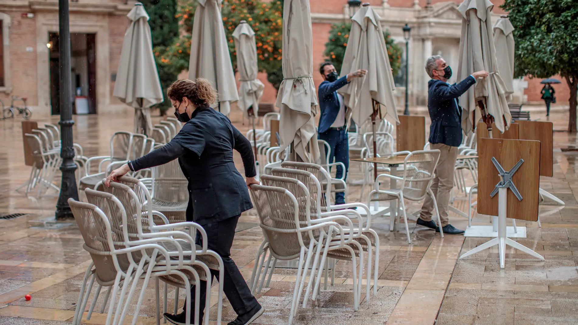 Unos trabajadores de un restaurante del centro de Valencia recogen la terraza.
