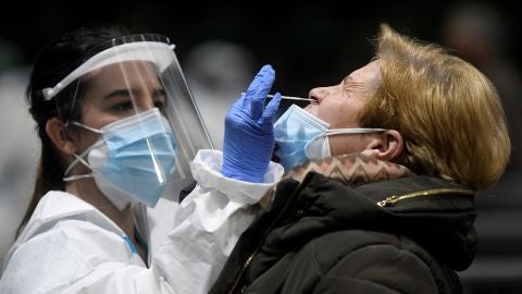 Imagen de una sanitaria realizando una PCR a una mujer