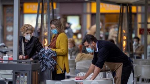 Un camarero limpia una terraza en Asturias