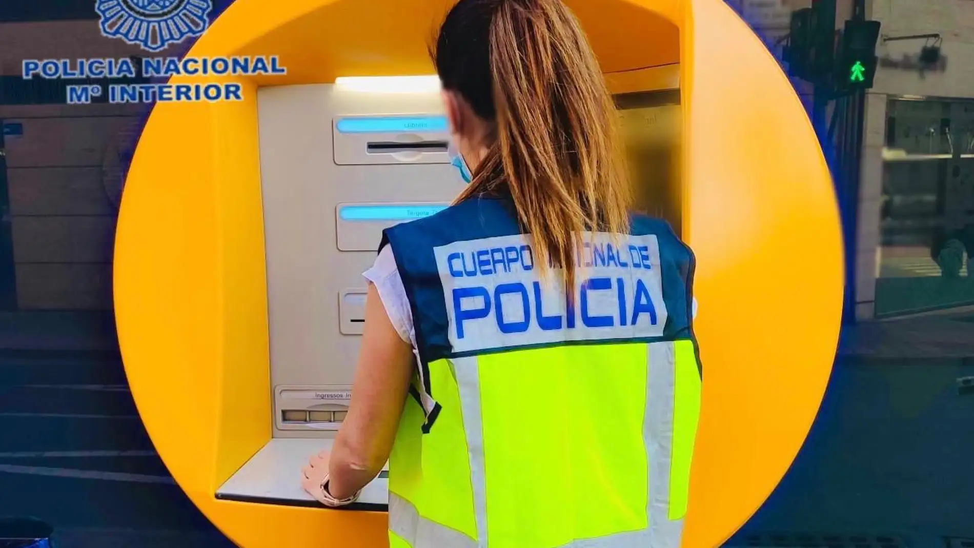 Una agente de la Policía Nacional de Elche en un cajero de la ciudad.