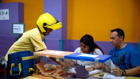 Elecciones Cataluña 2021: Un cartero entrega el voto por correo en una mesas electoral del Colegio Santa Marta de l&#39;Hospitalet de Llobregat