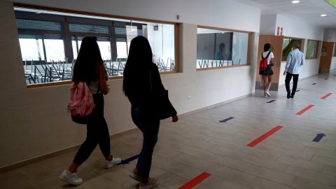 Varios estudiantes se dirigen a un aula por un pasillo en el IES Simone Veil de Paracuellos del Jarama, Madrid.