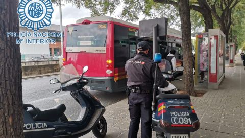 Un agente de la Policía Nacional frente a una parada de Tussam