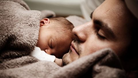 Un padre duerme junto a su beb&eacute;