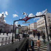 Ciudadanos caminan por la Puerta del Sol, en Madrid