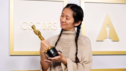 La directora de origen chino Chlo&eacute; Zhao mira la estatuilla que le acredita como ganadora del Oscar a la Mejor Direcci&oacute;n por 'Nomadland'