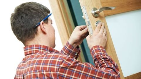 Un cerrajero trabajando en una puerta