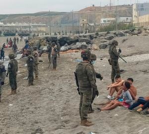 Miembros del Ejército observan a un grupo de inmigrantes que ha llegado a nado en los espigones fronterizos de Ceuta. Miembros del Ejército observan a un grupo de inmigrantes que ha llegado a nado en los espigones fronterizos de Ceuta.