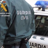 Un agente de la Guardia Civil junto a un coche patrulla. Un agente de la Guardia Civil junto a un coche patrulla.
