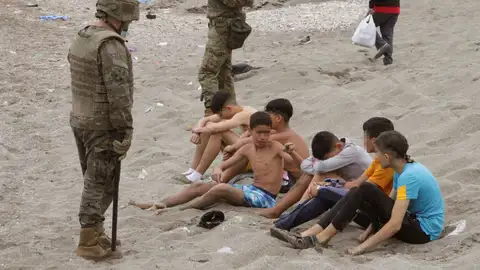 Miembros del Ejército de Tierra vigilan a un grupo de inmigrantes menores que han logrado cruzar uno de los espigones fronterizos de Ceuta Miembros del Ejército de Tierra vigilan a un grupo de inmigrantes menores que han logrado cruzar uno de los espigones fronterizos de Ceuta