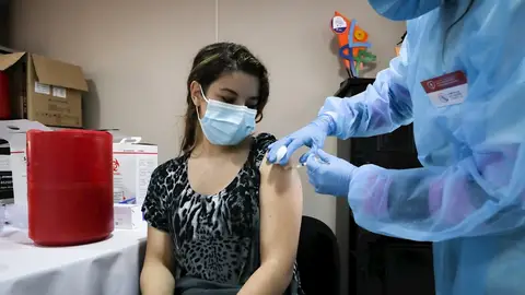 Una mujer siendo vacunada Una mujer siendo vacunada