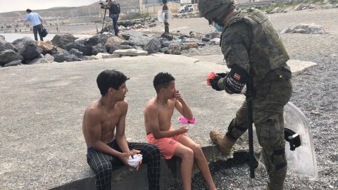 Un militar ayudando a dos Menas en Ceuta