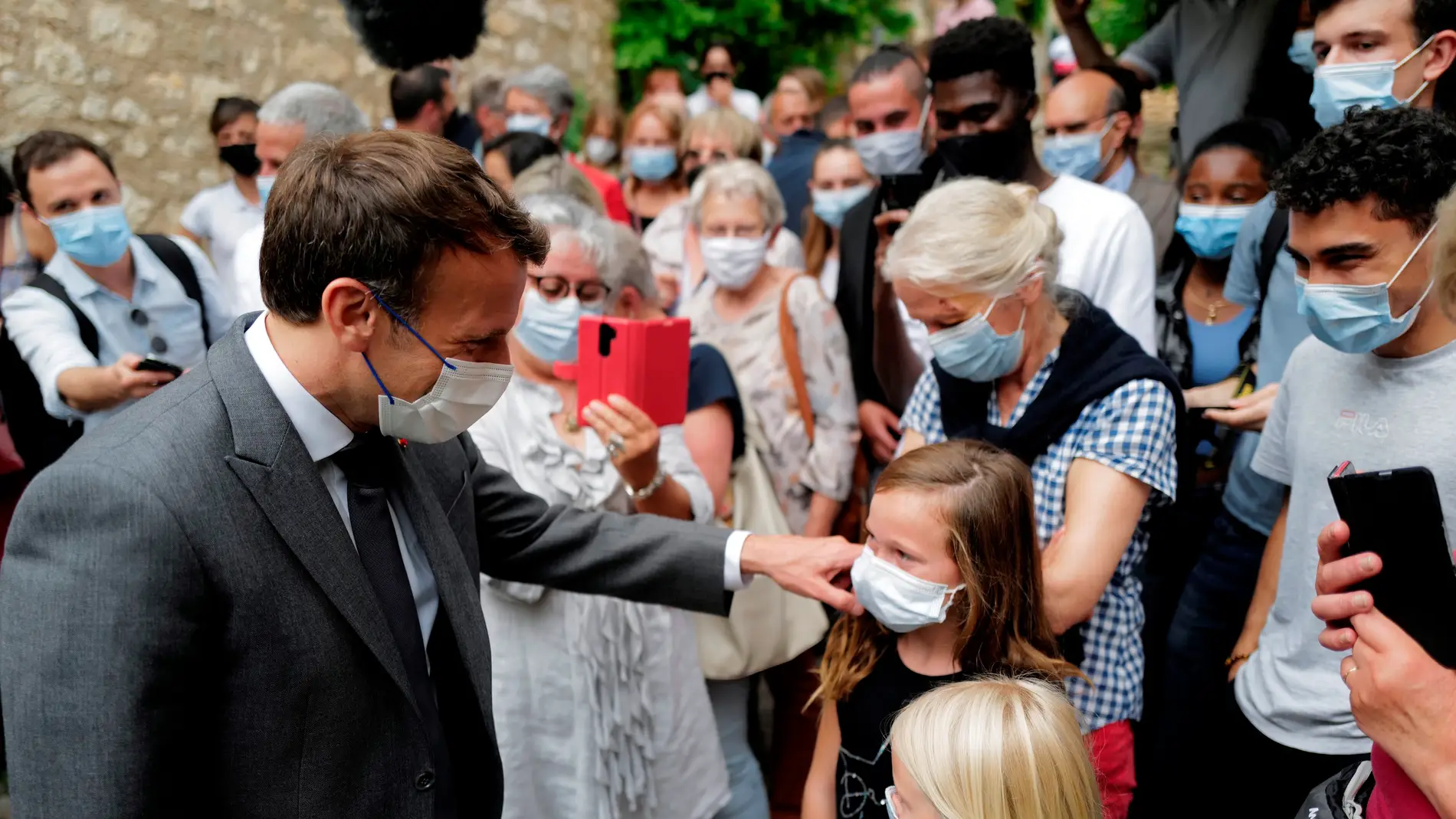 Macron, el presidente de Francia, saluda a varios ciudadanos.