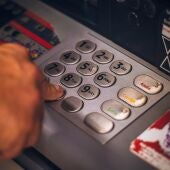 Una persona saca dinero en un cajero automático de un banco