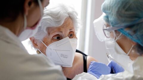 dos sanitarias poniendo una vacuna a una residente de un centro de mayores