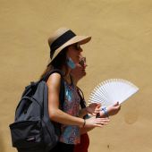 Varias personas se protegen del sol y el calor que se registra hoy en Córdoba