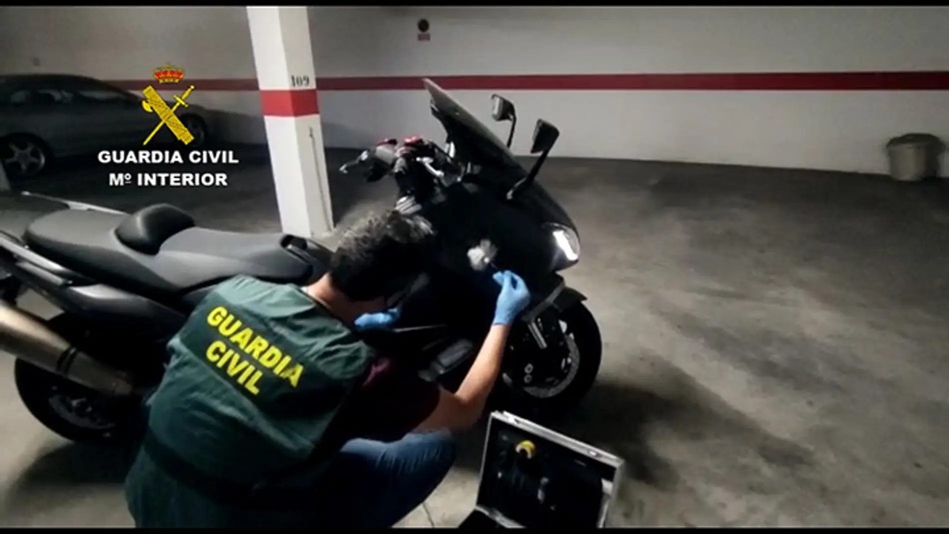 Un agente de la Guardia Civil junto a una de las motocicletas que adquirió el detenido. 