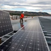 Un operari instal•la una placa solar Un operari instal•la una placa solar