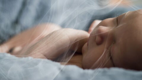 Un bebé respira el humo del tabaco