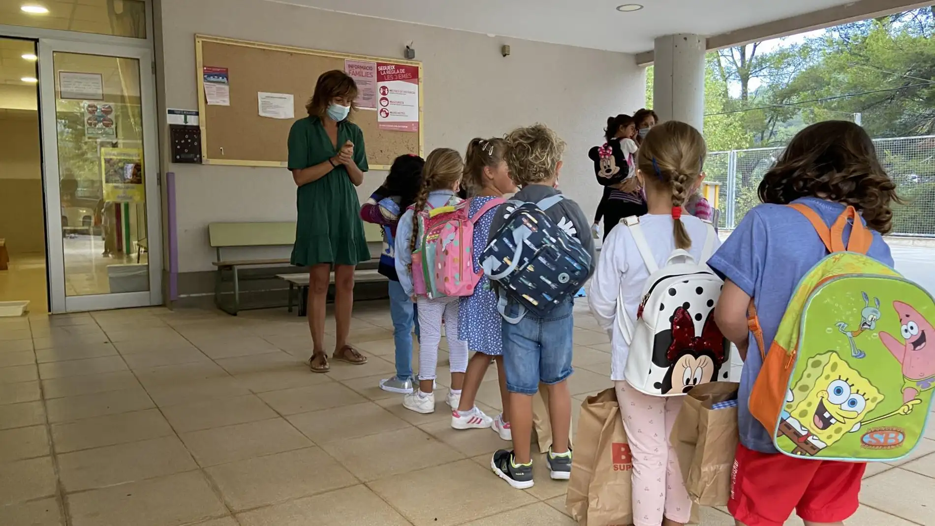 Una profesora recibe a los primeros estudiantes en un colegio de la isla. 