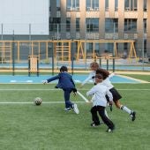 Niños jugando al fútbol en el colegio