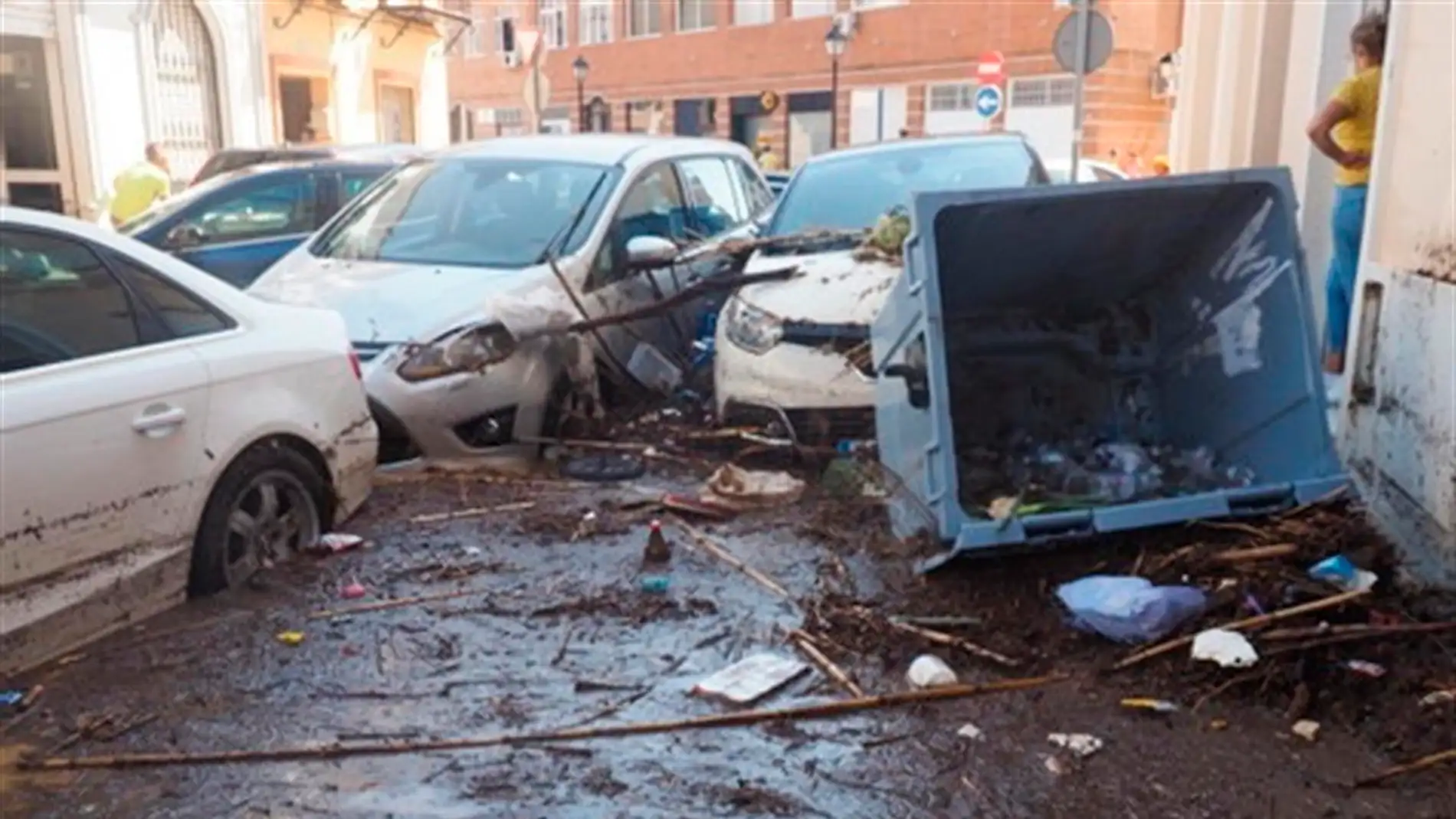 Una vecina de Lepe (Huelva) comprueba los daños en una calle de la localidad tras las fuertes lluvias