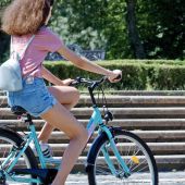 Una mujer pasea en bicicleta aprovechando el buen tiempo.