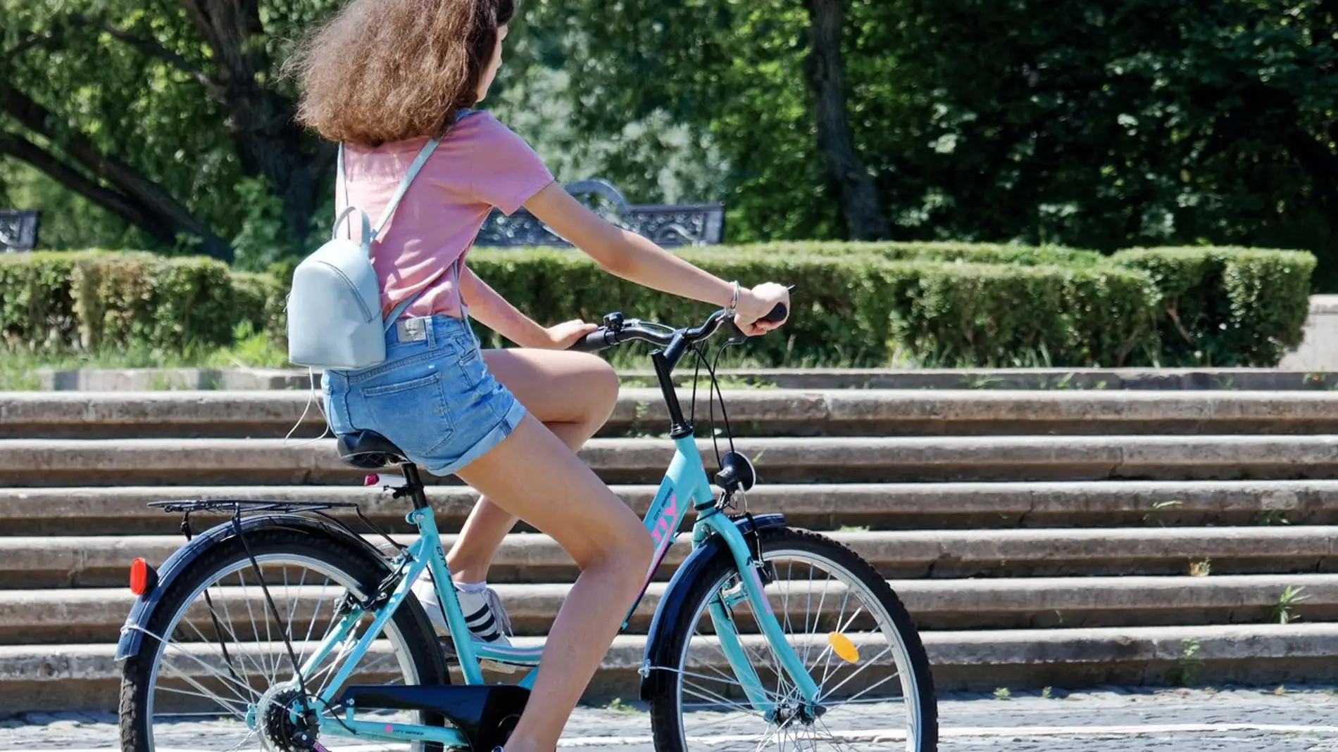 Una mujer pasea en bicicleta aprovechando el buen tiempo.