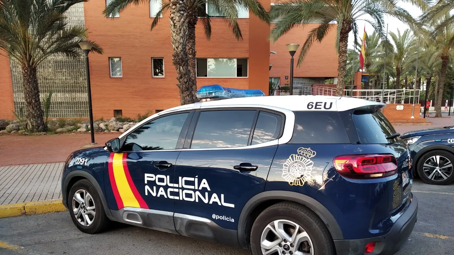 Vehículo patrulla de la Policía Nacional estacionado junto a la Comisaría de Elche.