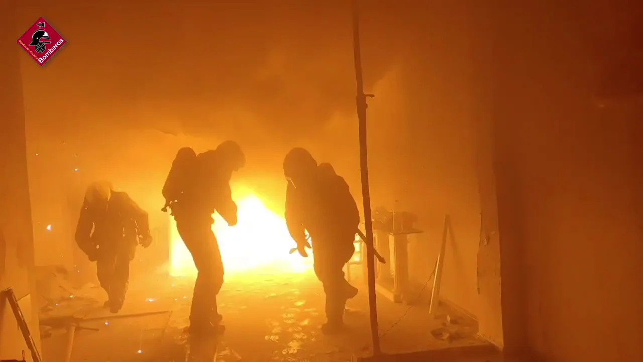 Efectivos de bomberos en el taller incendiado en Elche.