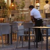 Un camarero prepara la terraza de un restaurante.