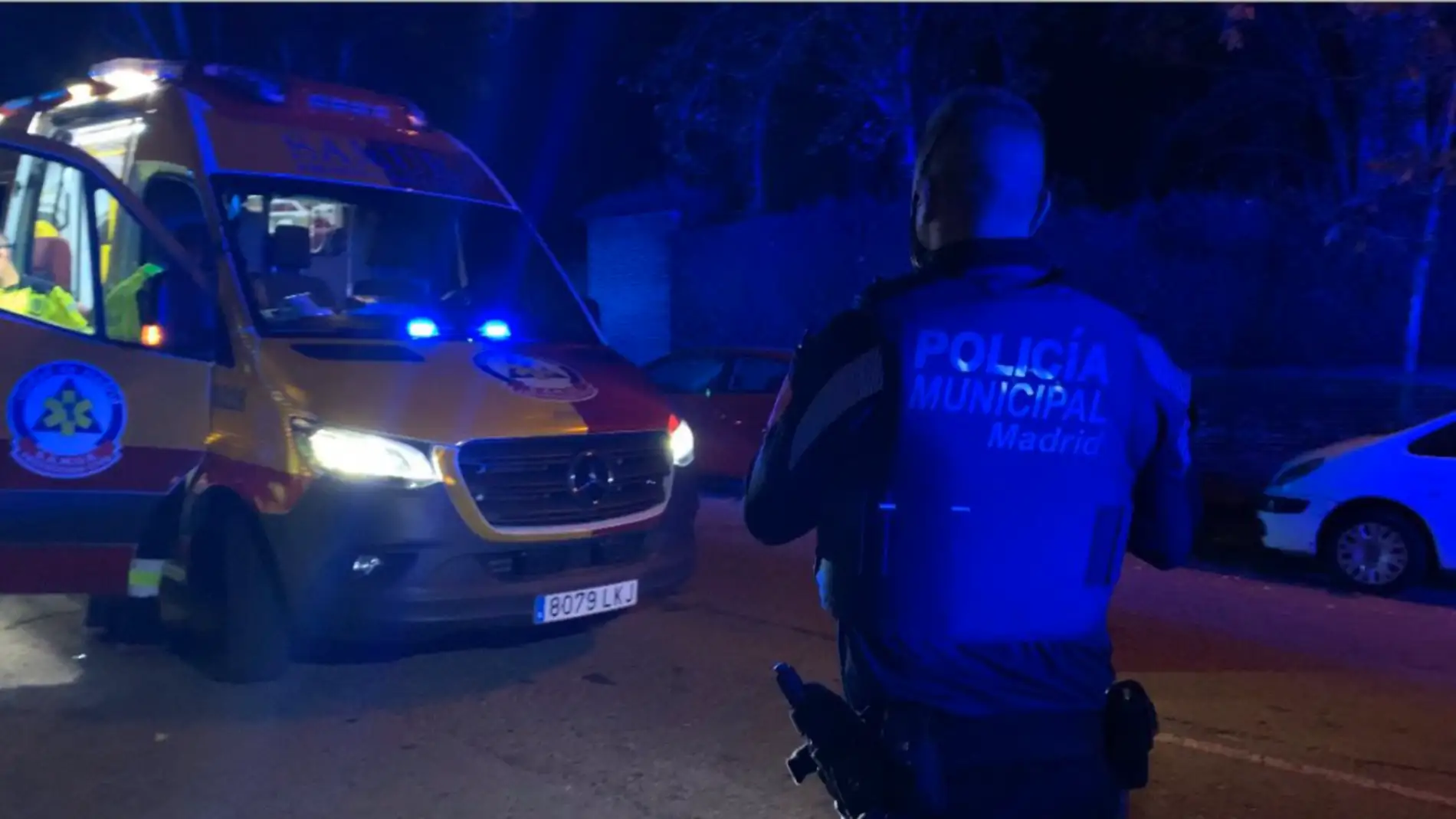 Un agente de la Policía Municipal de Madrid junto a una ambulancia del SAMUR