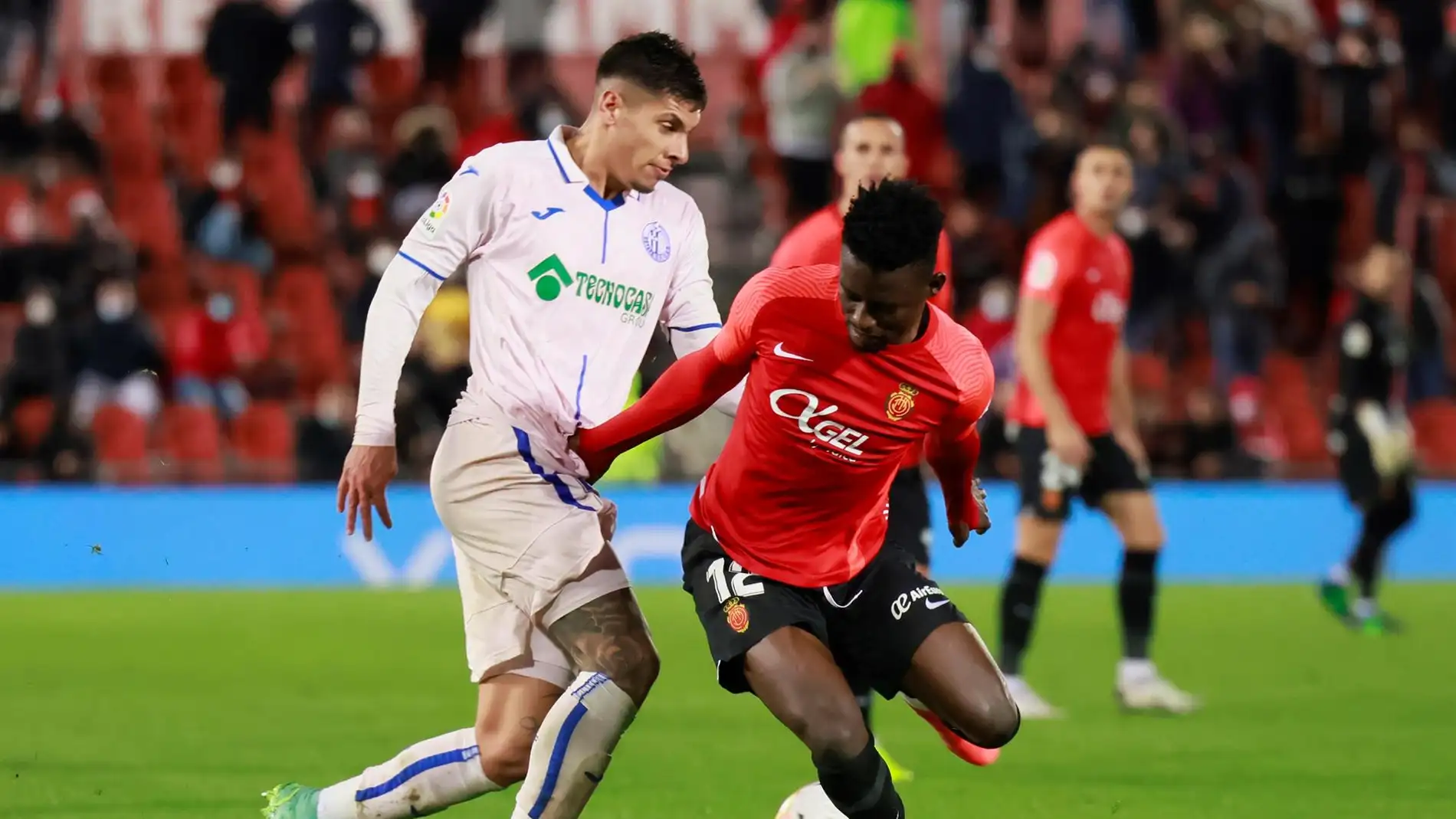 El centrocampista ghanés del Mallorca, Iddrisu Baba, disputa el balón ante el defensa uruguayo del Getafe, Mathias Olivera